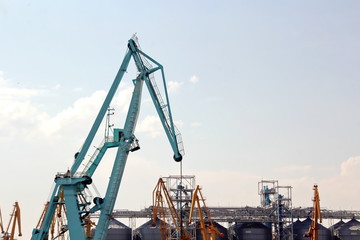 Cranes and masts against the blue sky.