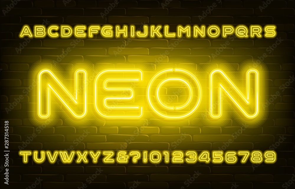Fototapete yellow neon alphabet font. bright light bubble letters and numbers on brick wall background. stock v