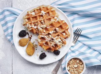 Belgian waffles with syrup, berries and honey, breakfast on a light background, Selective focus