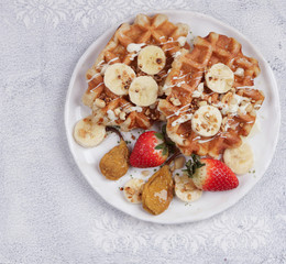 Belgian waffles with syrup, berries and honey, breakfast on a light background, Selective focus