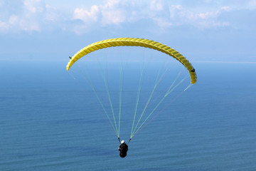 Paraglider flying over the sea