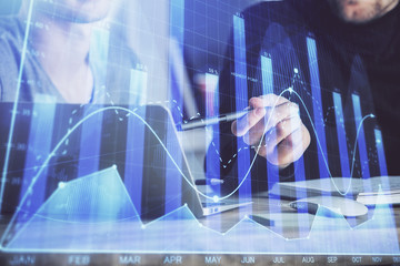 Forex graph with businessman typing on computer in office on background. Concept of analysis. Double exposure.