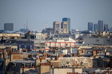 Notre Dame de Paris avec des toits et des cheminées en premier plan