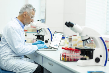 Concentrated mature researcher working at his project