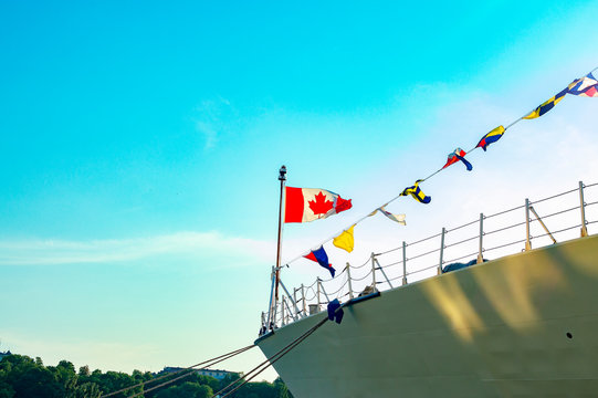 Canada flag waving on the mast of a warship.