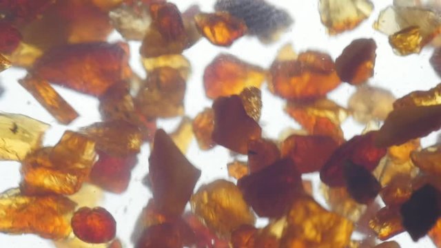 pieces of amber in water falling to the bottom slow motion