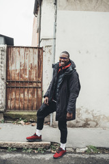 young african man standing in the street and looking camera