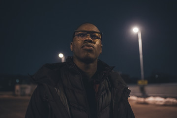 portrait of young african man standing in the street and looking further