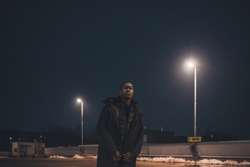 young african man standing in the street and looking camera