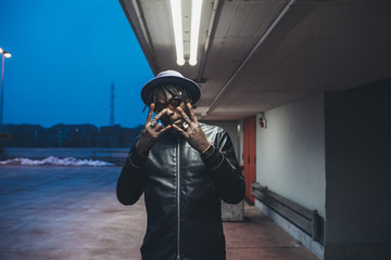 young  african bearded man outdoors posing looking camera