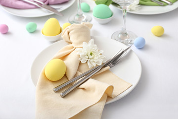 Table setting for Easter celebration on white background