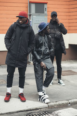 three young african men posing together in the street