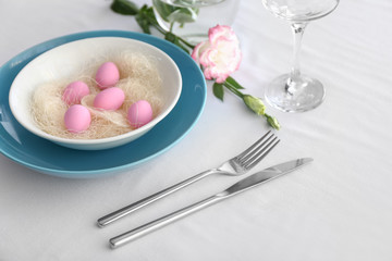 Table setting for Easter celebration on white background