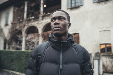 portrait young african man standing alone and looking further