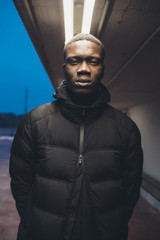 portrait of young african man standing outside and looking camera