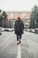 young bearded african man outdoors walking looking camera smiling