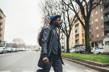 young african man standing in the street and smoking cigar