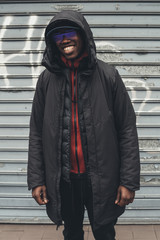 young african man standing in the street and looking camera