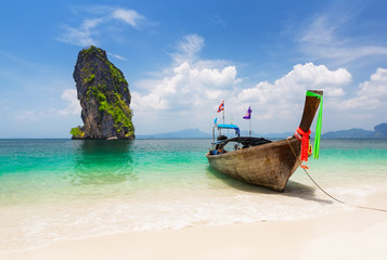 Thai traditional wooden longtail boat and beautiful sand beach.