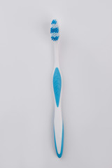 Blue tooth brush on white wooden background. New plastic tooth brush. Oral hygiene concept.