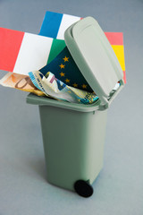 Eurozone crisis concept, flags of the countries of the European Union, euro banknotes in the garbage can 