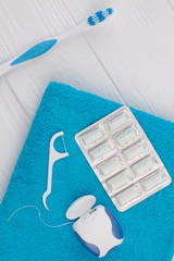 Toothbrush, dental floss, chewing gums and towel. Dental care products. Flat lay, top view.