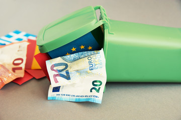 Eurozone crisis concept, flags of the countries of the European Union, euro banknotes in the garbage can 