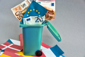 Eurozone crisis concept, flags of the countries of the European Union, euro banknotes in the garbage can 