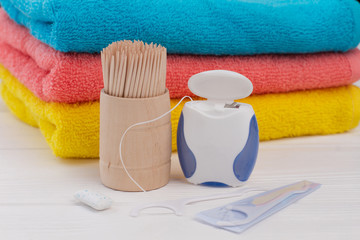 Dental hygiene background. Stack of bath towels, dental floss, wooden toothpicks and chewing gums. Make your teeth healthy.