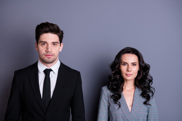 Portrait of concentrated man and woman with brunet wavy curly hair looking wearing black blazer tie jacket isolated over grey background