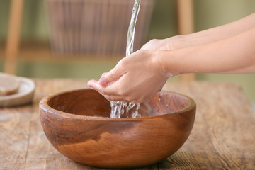 Woman washing hands under water in bathroom
