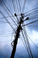 Old wooden electricity pole with multiple cables