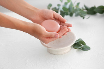 Woman with soap bar in bathroom, closeup