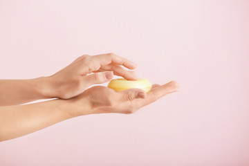 Fototapeta na wymiar Female hands with soap bar on light background