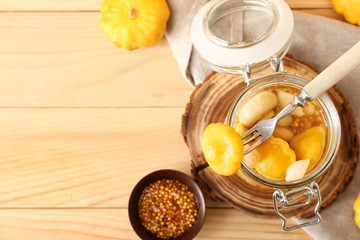 Jar with canned squashes on wooden table