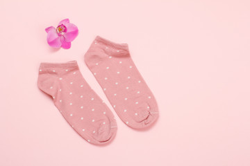 Pair of women socks on pink background.