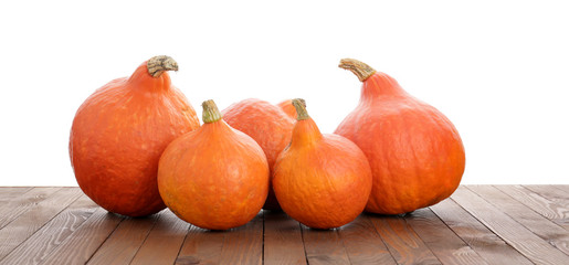 Fresh pumpkins on wooden table against white background