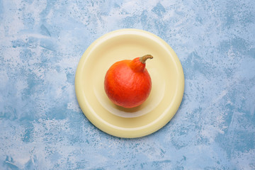 Plate with fresh pumpkin on color background