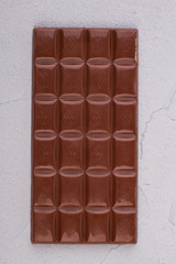 Bar of chocolate, top view. Milk chocolate bar. Unhealthy food concept.