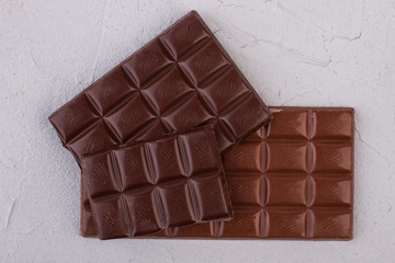 Milk and dark chocolate bars. Different chocolate bars on light background. Health benefits of eating chocolate.