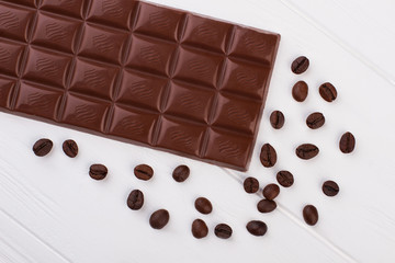 Dark chocolate bar and coffee beans. Health benefits of eating chocolate.