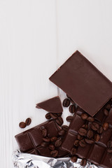 Chocolate and coffee beans, top view. Dark chocolate bars, coffee beans and copy space.