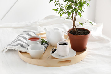 Tray with hot tea on bed in morning