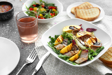 Plate with tasty salad on table