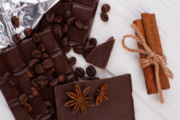 Chocolate, coffee beans and cinnamon. Dark chocolate pieces, star anise and cinnamon sticks on white background.