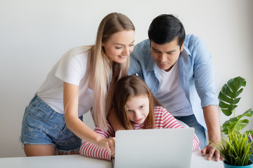 mother, father advise daughter for using laptop computer at home together at home, young family concept