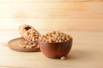 Bowl and scoop with raw chickpea on table