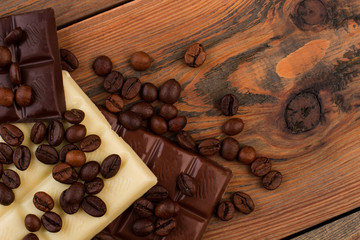 Chocolate bar with coffee beans. Coffee beans and chocolate on brown wooden background. Space for text.