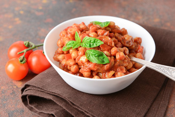 Bowl with tasty chickpea in tomato sauce on table