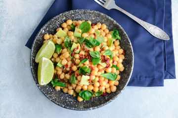 Plate with tasty chickpea salad on table